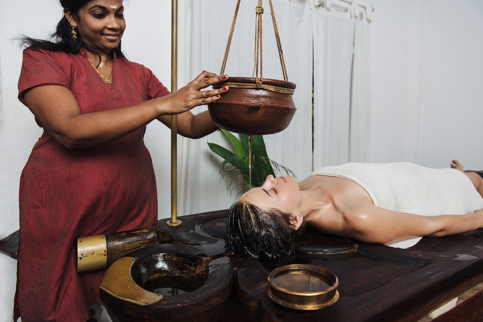 Caucasian woman having Ayurveda shirodhara treatment in India, Kerala state